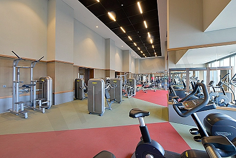 Modern spor salonu ekipmanları ile donatılmış iç mekan görüntüsü.