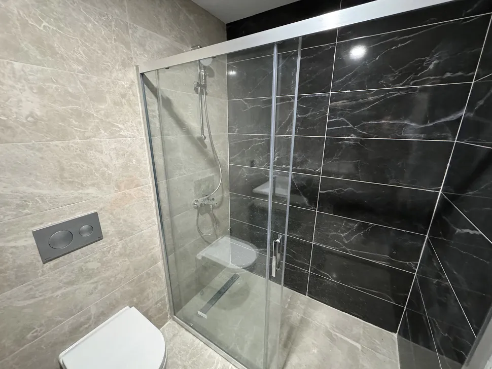Modern seramik kaplamalı, geniş ve aydınlık bir banyo tasarımı.