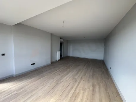 Modern mimariye sahip, geniş pencereli ve ferah bir oturma odası alanı.