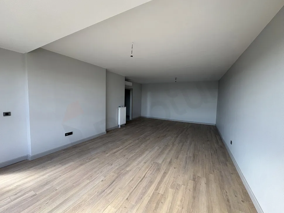 Modern mimariye sahip, geniş pencereli ve ferah bir oturma odası alanı.