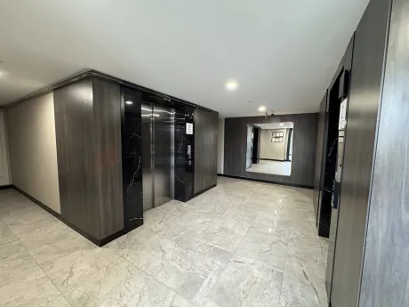 Modern ve geniş tasarıma sahip lüks bir apartman lobisi.