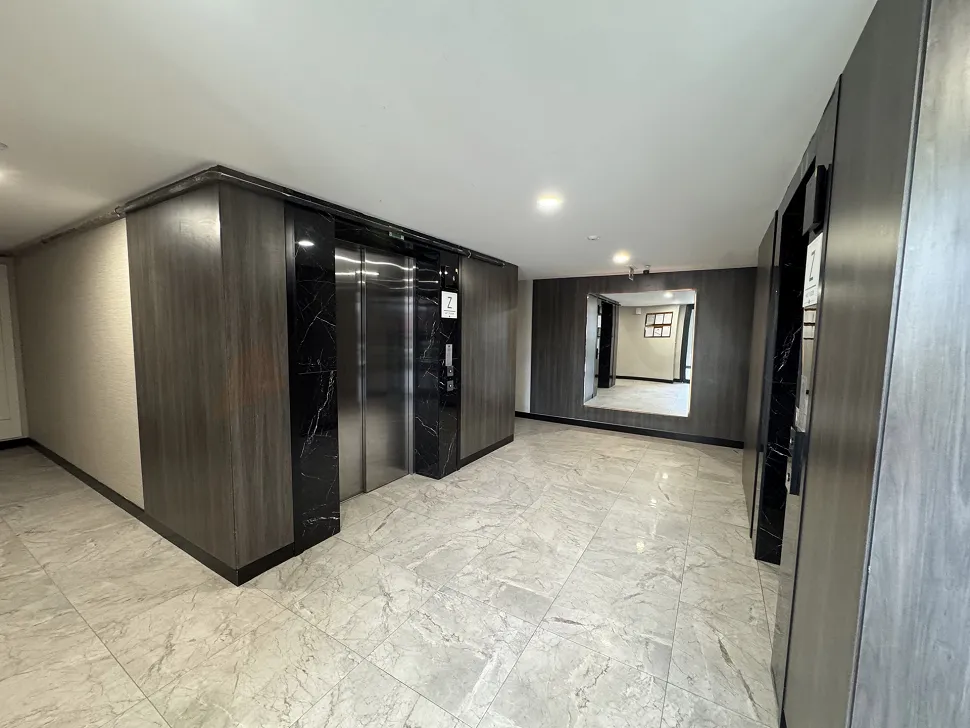 Modern ve geniş tasarıma sahip lüks bir apartman lobisi.