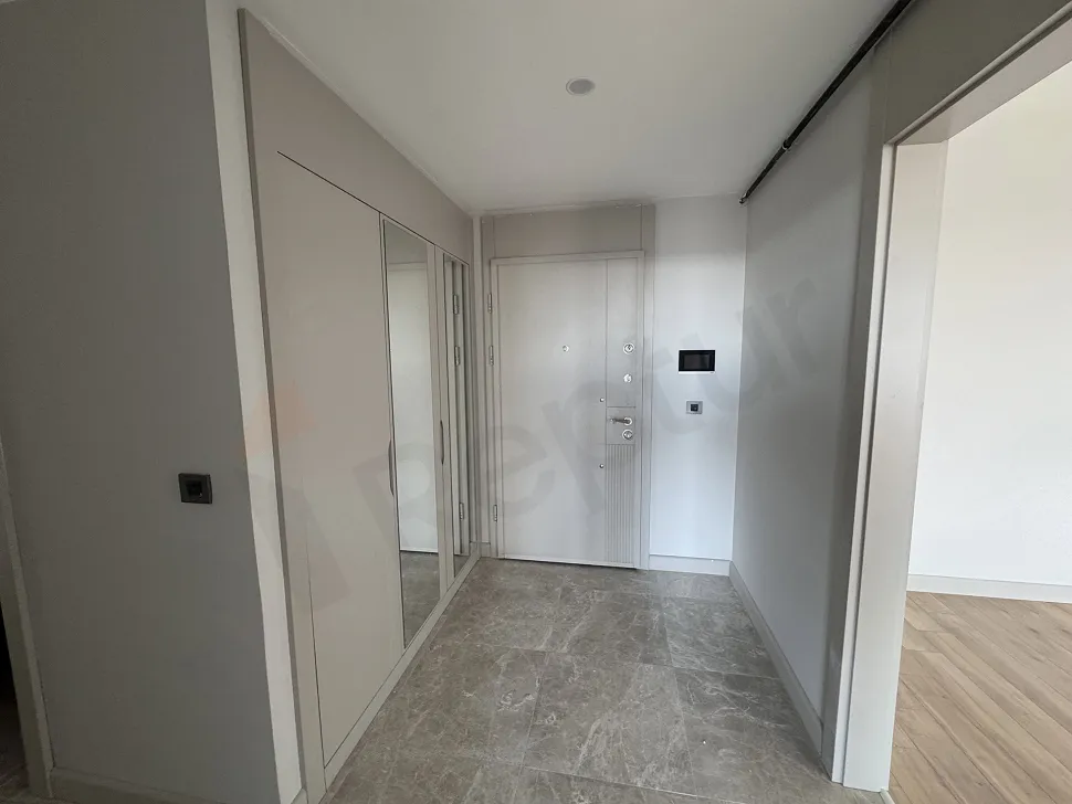 Modern bir dairenin giriş holü ve şık çelik kapı görünümü.