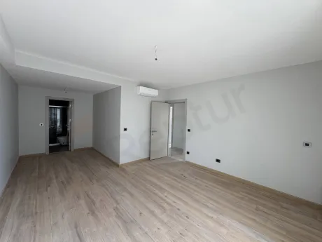 Modern bir dairenin geniş ve aydınlık yatak odası iç mekan görünümü.