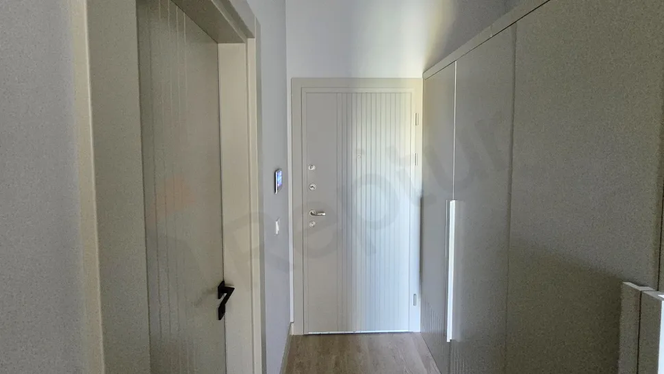 Modern bir dairenin giriş kapısı ve giriş holü görünümü.