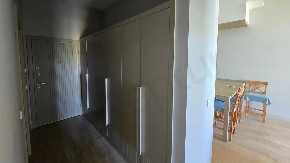 Modern ve aydınlık bir dairenin geniş koridor görünümü.
