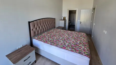 Geniş pencereli, aydınlık ve modern bir yatak odası görünümü.