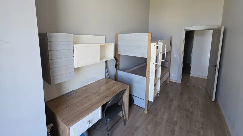 Modern ve aydınlık tasarıma sahip, geniş pencereli ferah bir yatak odası görseli.