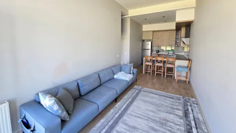 Geniş pencereli, ferah ve modern mimari detaylara sahip aydınlık oturma odası.