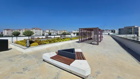 Modern bir binanın şehir manzarasına bakan geniş ve boş teras alanı.