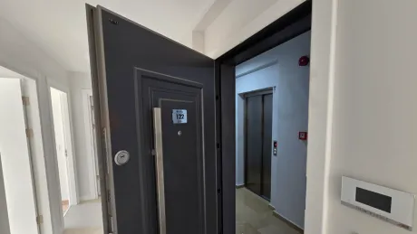 Modern bir binada yer alan dairenin giriş kapısı ve antre bölümü.