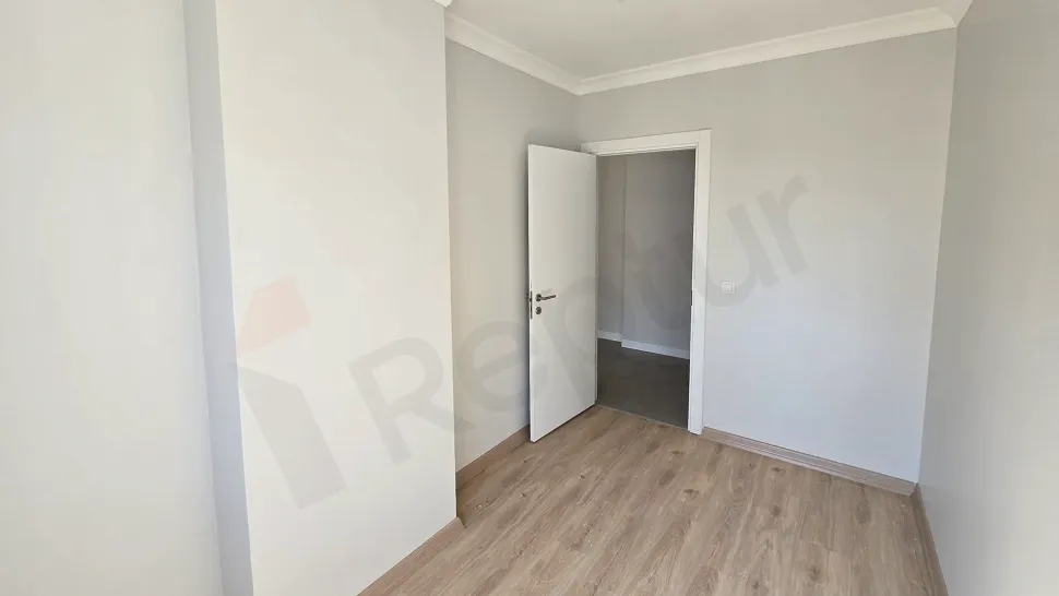 İstanbul Küçükçekmece'de satılık modern bir dairenin geniş ve ferah yatak odası görünümü.