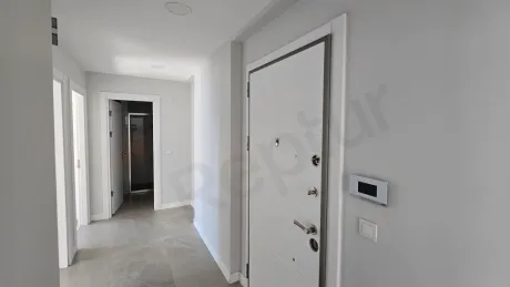 Modern bir binada yer alan şık ve aydınlık daire giriş kapısı ve antre bölümü.
