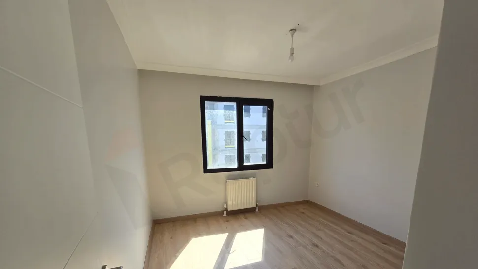 Modern bir dairenin geniş ve ferah yatak odası alanı.