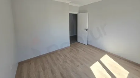 İstanbul Küçükçekmece'de satılık 2+1 dairenin geniş ve gün ışığı alan boş yatak odası görseli.