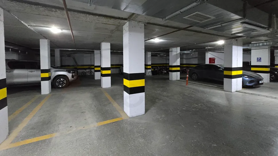 Modern bir binanın geniş ve güvenli kapalı otopark alanı