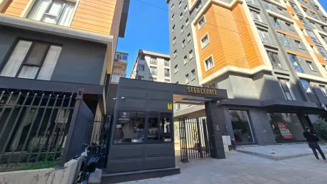 Modern bir konut sitesinin girişinde bulunan güvenlik kapısı ve kontrol noktası.