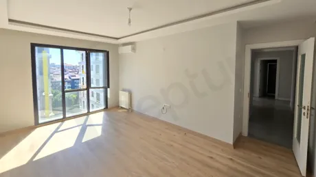 Modern bir dairenin geniş ve gün ışığı alan ferah oturma odası görünümü.
