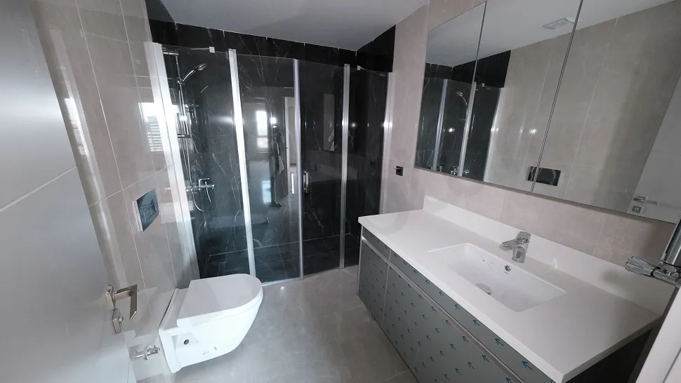 Modern tasarımlı, kaliteli seramiklerle döşenmiş şık bir banyo iç mekanı.