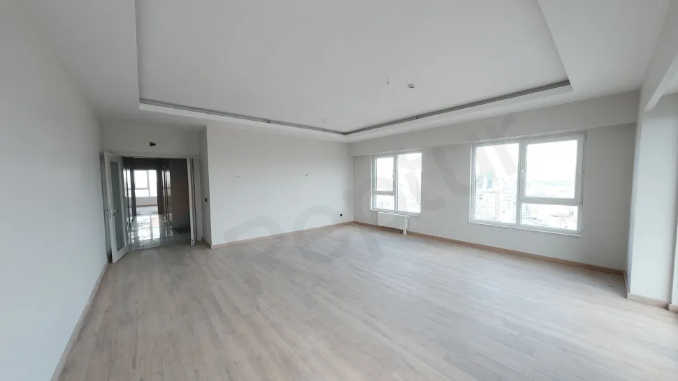 Geniş pencereli, ferah ve gün ışığı alan modern bir oturma odası alanı.