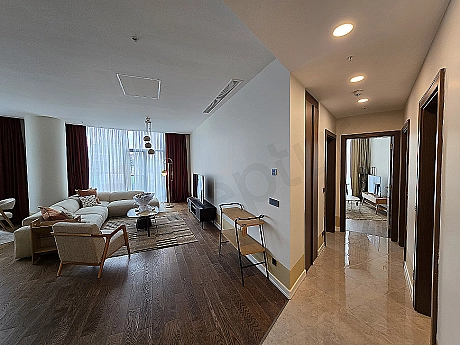 Şık ve modern oturma odası tasarımı, konforlu köşe koltuk, ahşap detaylar ve doğal ışık.