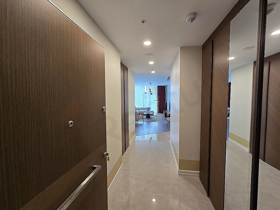 Modern daire giriş alanı, ahşap kapı ve şık aydınlatma detayı