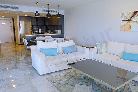 Eşyalı oturma odası, modern mobilyalar ve aydınlatma ile dekore edilmiş geniş ve konforlu bir yaşam alanı.
