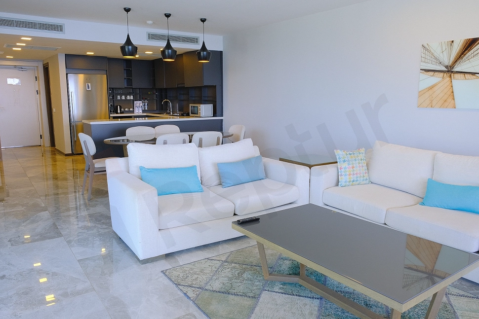 Eşyalı oturma odası, modern mobilyalar ve aydınlatma ile dekore edilmiş geniş ve konforlu bir yaşam alanı.