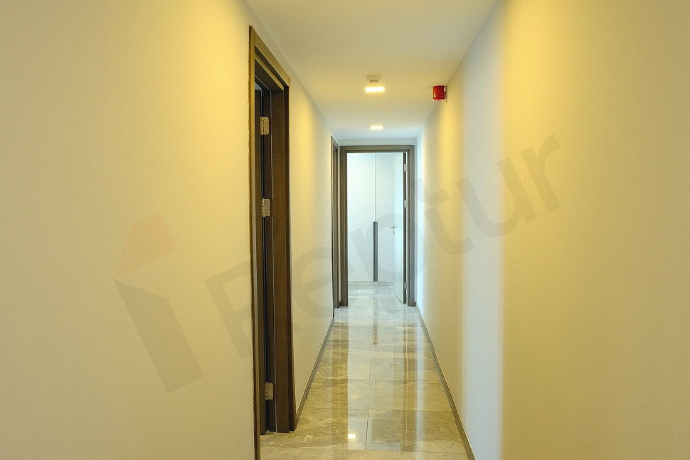 Modern tasarıma sahip, ferah bir dairenin iç koridoru. Açık renk duvarlar ve aydınlık bir ambiyans.