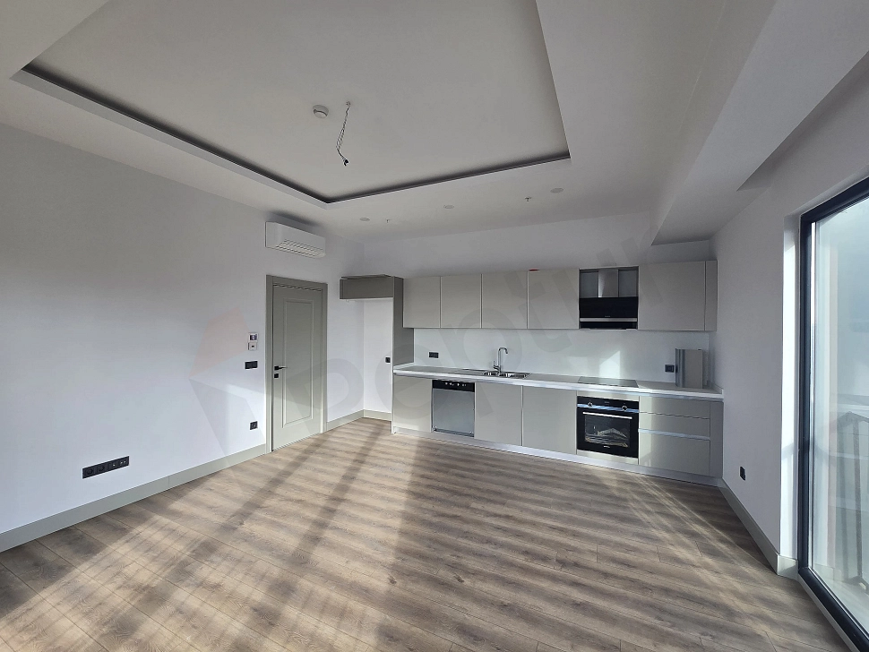 Modern tasarımlı, eşyasız daire mutfağı.