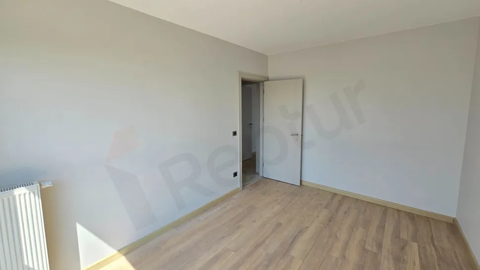 Yeni binada yer alan, geniş pencereli ve modern tasarımlı aydınlık bir yatak odası görseli.