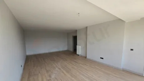 Geniş pencereli, ferah ve modern mimariye sahip lüks bir oturma odası görünümü.