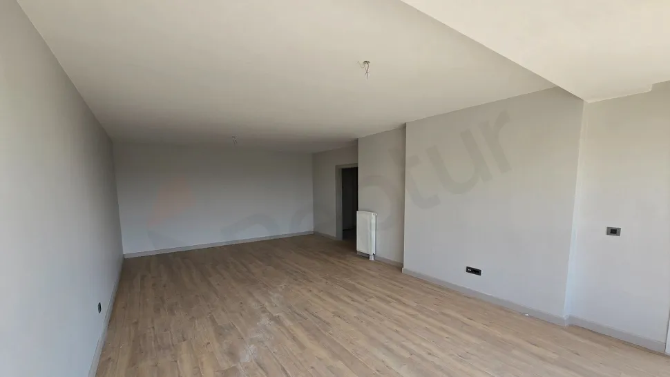 Geniş pencereli, ferah ve modern mimariye sahip lüks bir oturma odası görünümü.