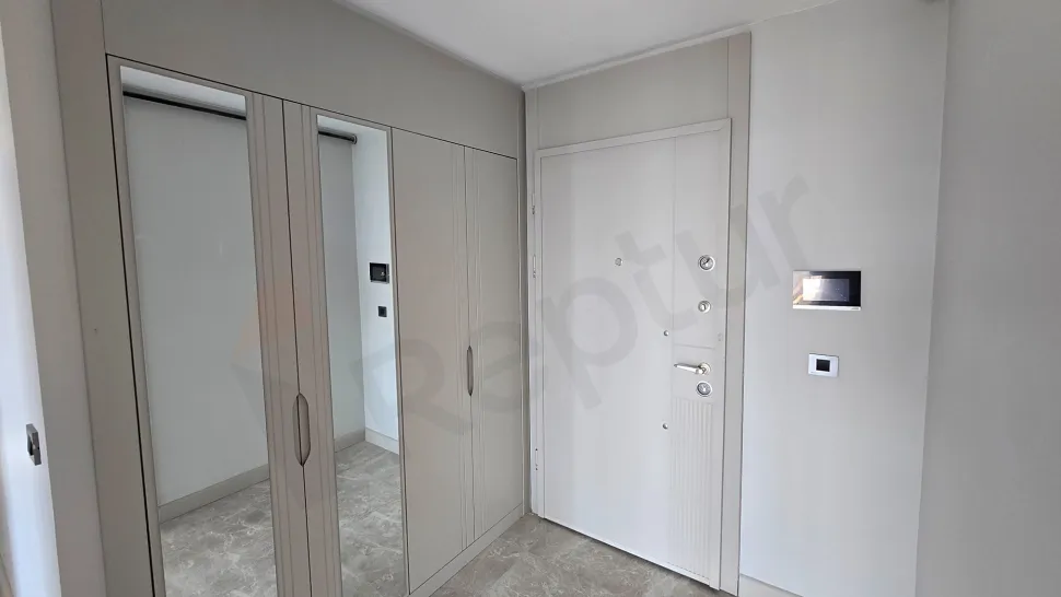 Yeni ve modern bir dairenin şık giriş holü ve çelik kapı alanı.