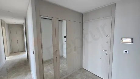 Modern bir dairenin giriş kapısı ve geniş antre bölümü.