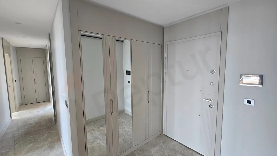 Modern bir dairenin giriş kapısı ve geniş antre bölümü.