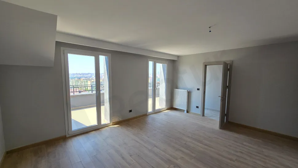 Modern tasarımlı, geniş ve aydınlık bir yatak odası görseli.