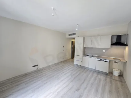 Geniş pencere yapısına sahip modern ve ferah bir stüdyo dairenin oturma odası görünümü.
