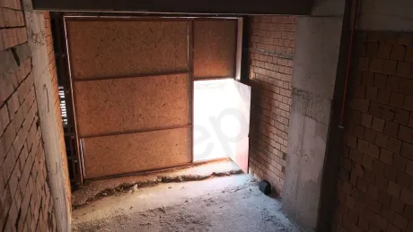 Beton zemin ve duvarlara sahip inşaat halindeki natamam dükkan iç mekanı.