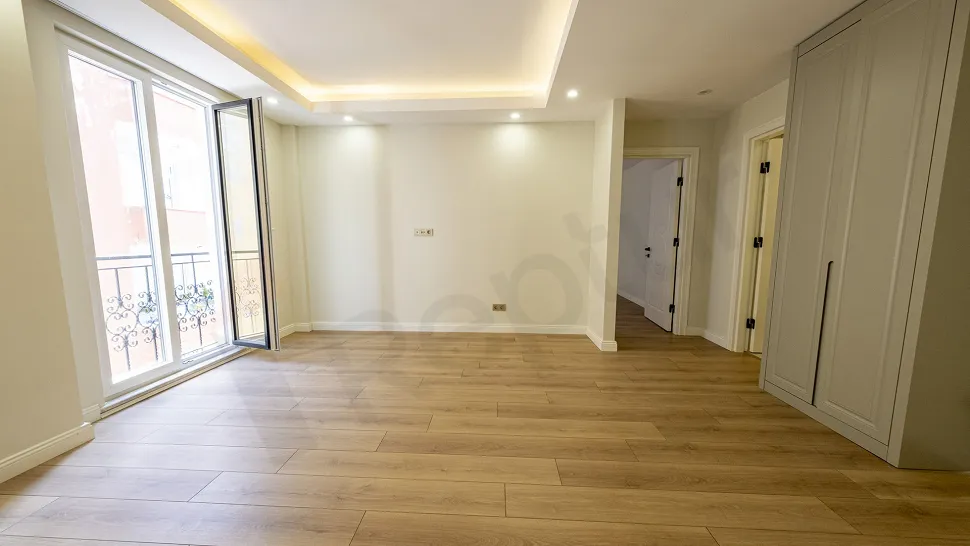 Beyoğlu'nda modern mimariye sahip, geniş pencereli ve ferah bir 1+1 dairenin oturma odası alanı.