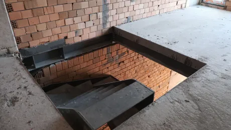 Modern tasarımlı, geniş basamaklı bina içi merdiven yapısı.