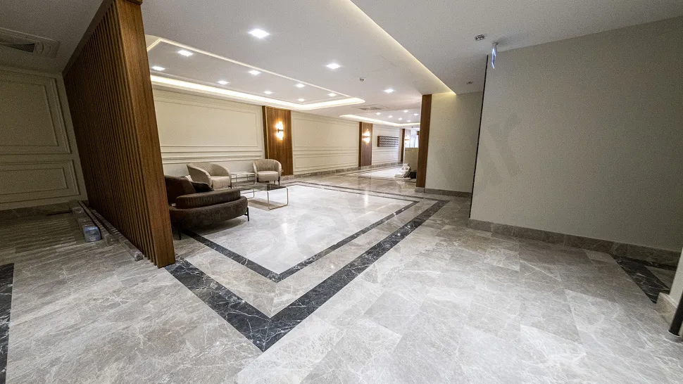 Modern ve şık tasarıma sahip, geniş ve aydınlık bir binanın lüks lobi alanı.