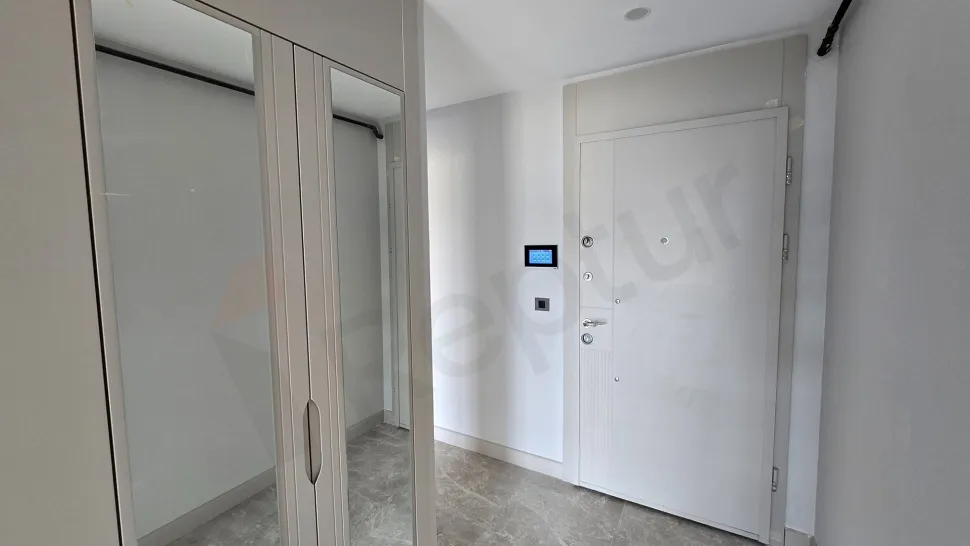 Modern tasarımlı bir dairenin giriş holü ve giriş kapısı detaylı görünümü.