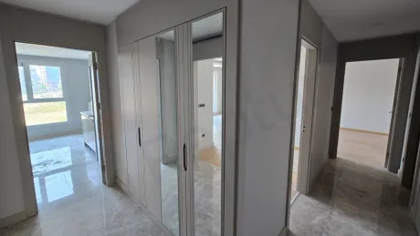 Modern bir binanın iç kısmında yer alan şık ve yeni tasarımlı daire giriş kapısı ve antre bölümü.