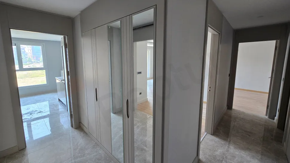 Modern bir binanın iç kısmında yer alan şık ve yeni tasarımlı daire giriş kapısı ve antre bölümü.