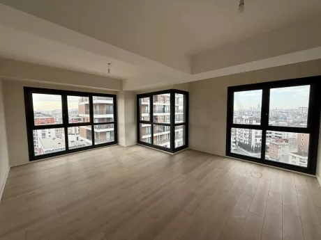 Modern ve geniş bir dairenin gün ışığı alan ferah oturma odası.