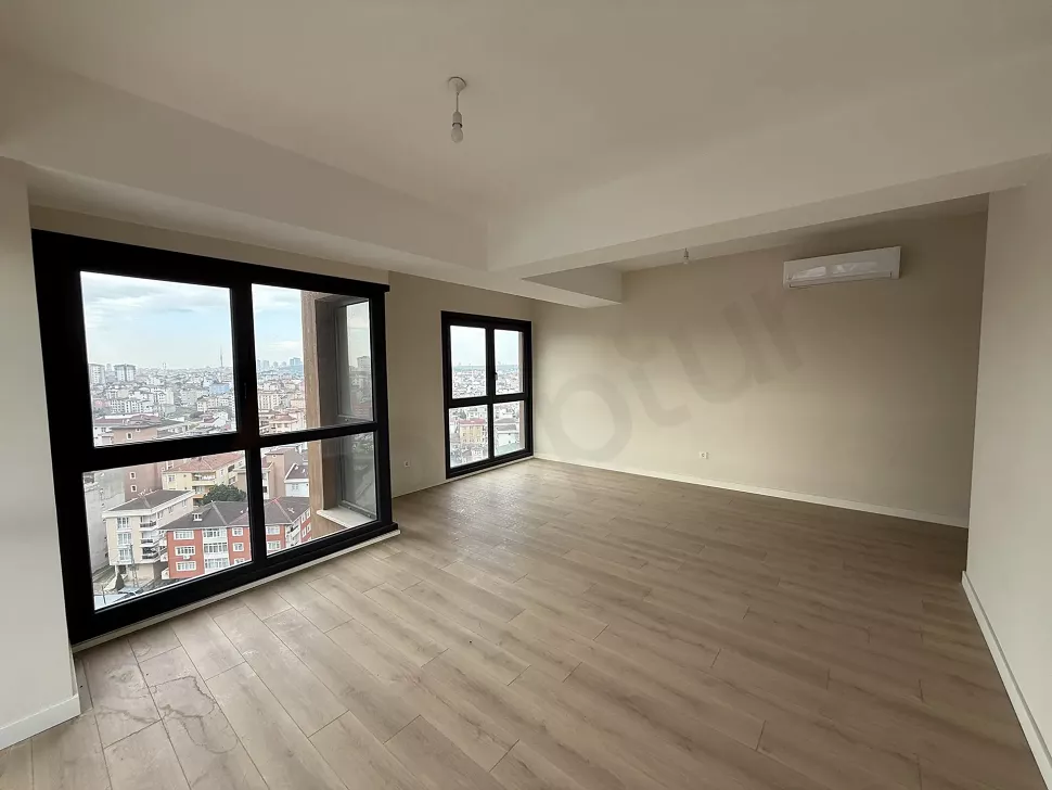 Modern mimariye sahip, geniş pencereli ve ferah oturma odası alanı.