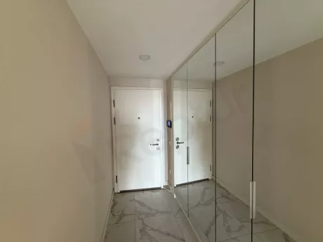 Modern bir dairenin geniş giriş holü ve giriş kapısı görünümü.