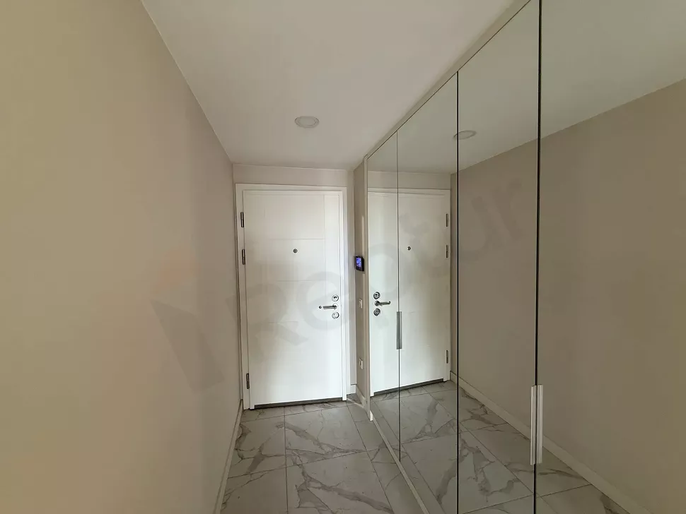 Modern bir dairenin geniş giriş holü ve giriş kapısı görünümü.