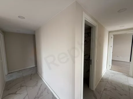 Yeni inşa edilmiş modern bir binanın içindeki geniş ve aydınlık koridor görünümü.